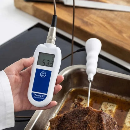 Une personne tenant une Thermometre.fr Sonde de pénétration thermocouple à code couleur dans une casserole.