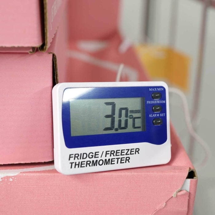 Un thermomètre numérique Thermomètre.fr trône au sommet d'un caisson de réfrigérateur.