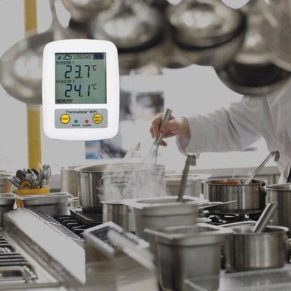 Un chef cuisine dans une cuisine avec un thermomètre digital Thermometre.fr.